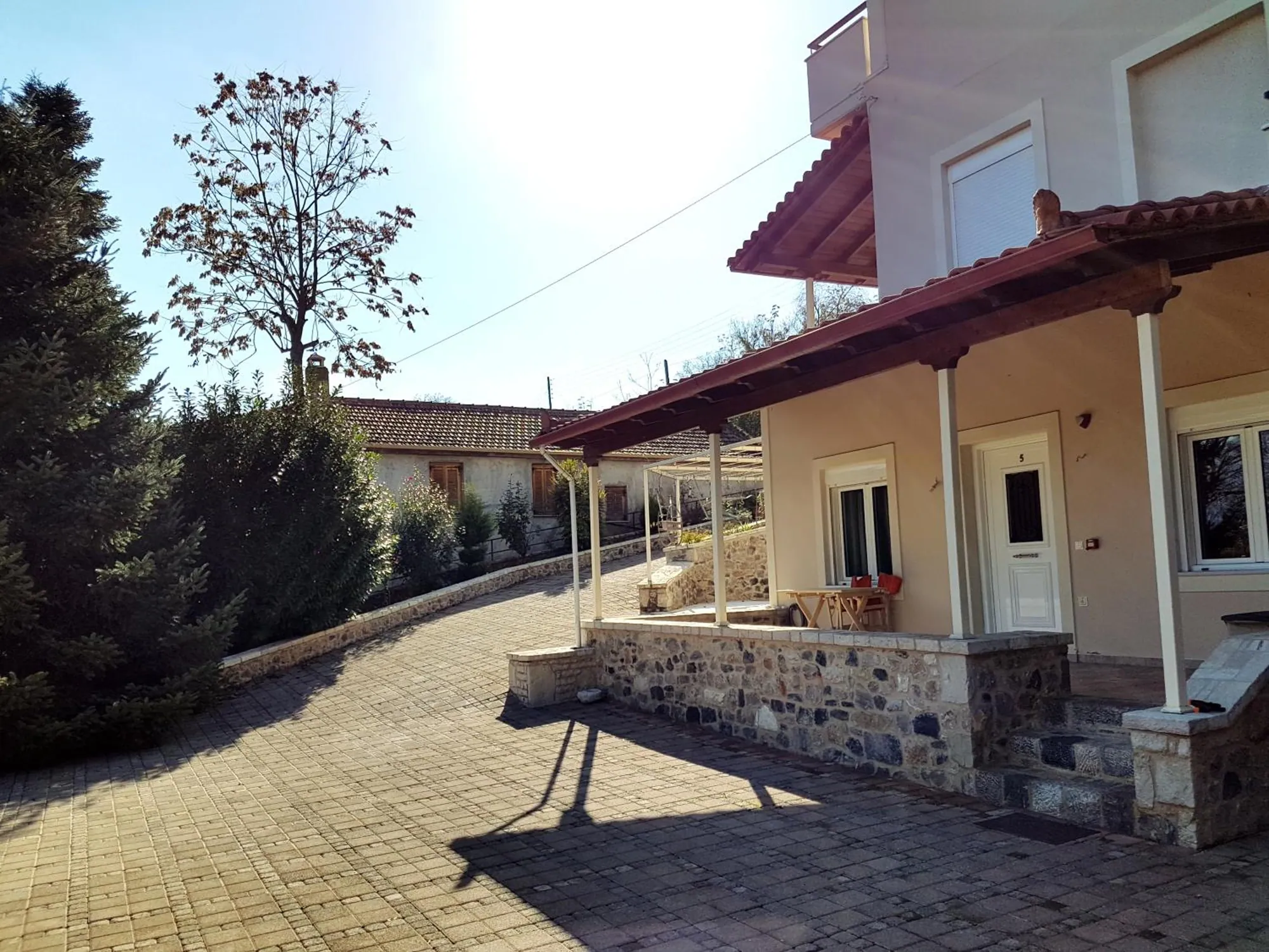 Η πλακόστρωτη αυλή μπροστά στα δωμάτια του ισογείου